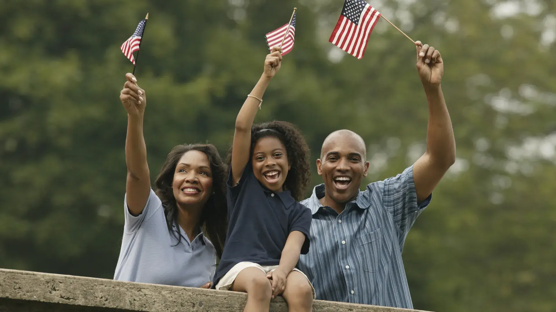 a family waving american flags