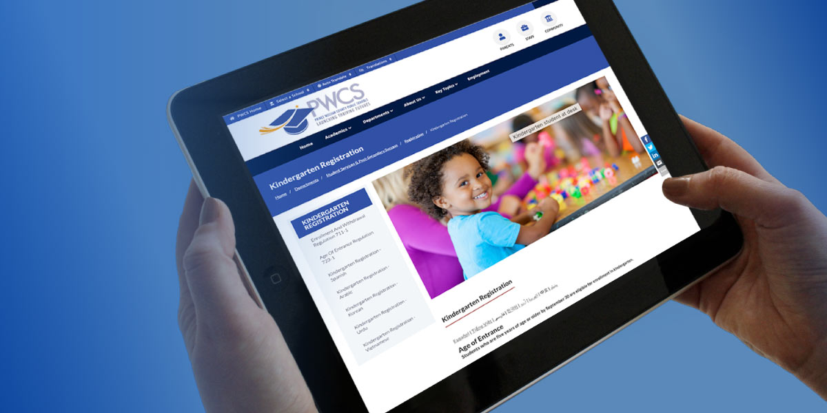 Hands on an iPad.  The iPad is on the PWCS registration website with a picture of a smiling child on it.